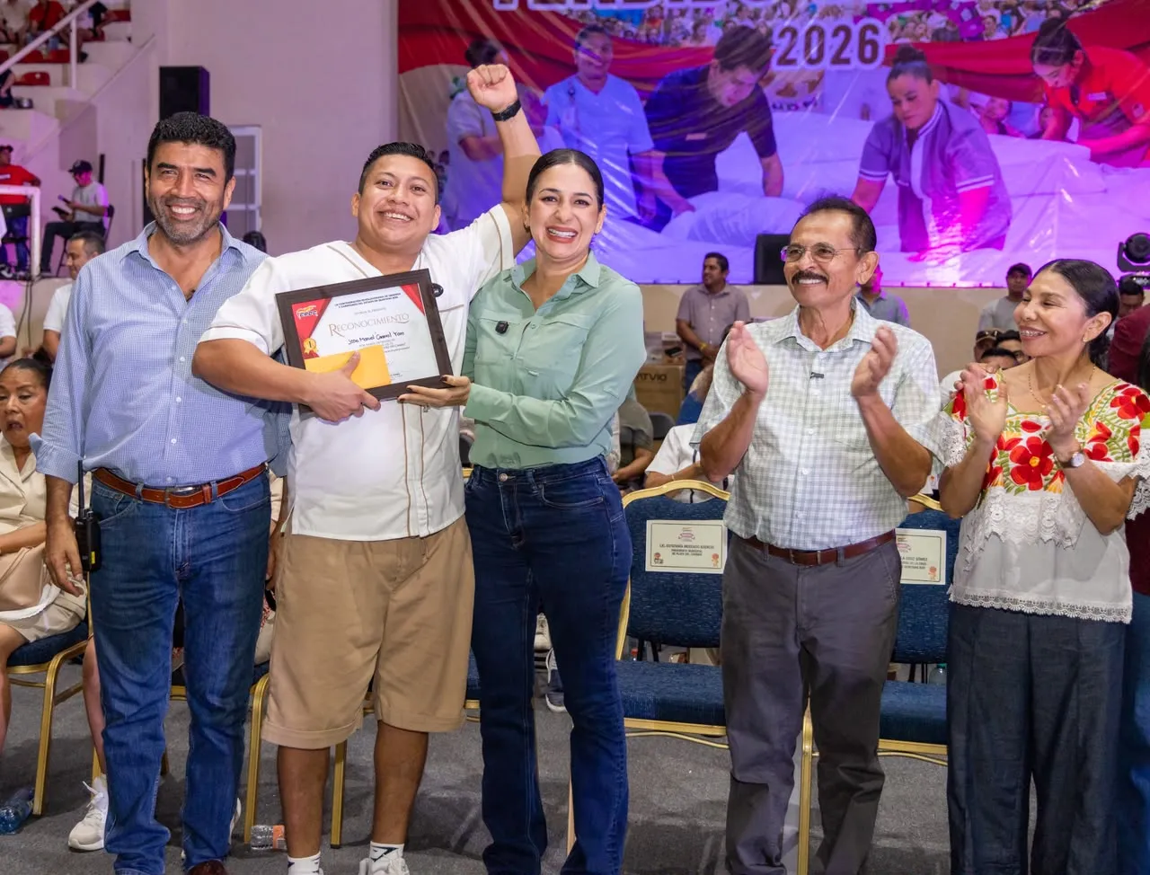 La presidenta municipal Estefanía Mercado entrega un reconocimiento a un trabajador hotelero